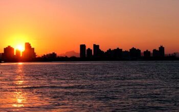 Rio Itajaí-Açu em dia de cheia com águas elevadas próximas à margem urbanizada.
